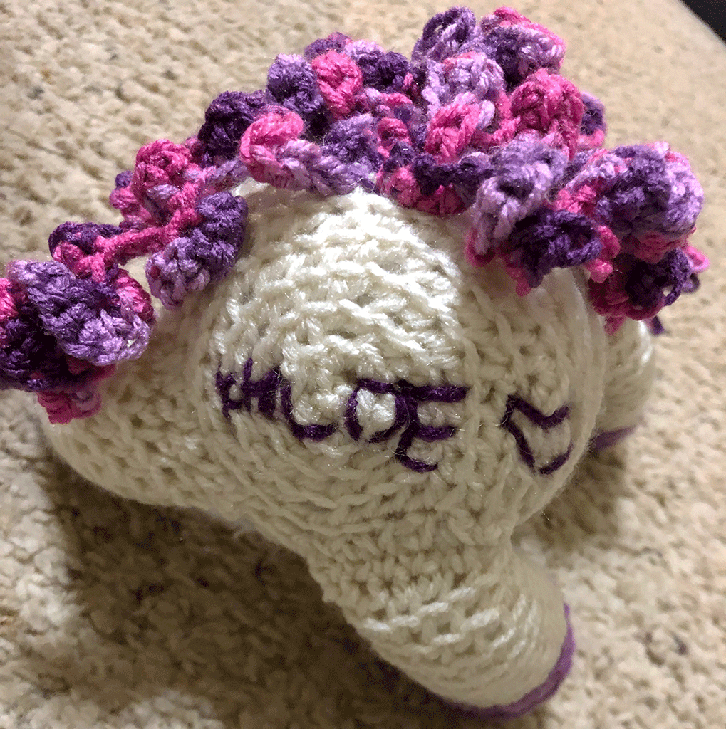 Picture of a crocheted stuffed animal as a unicorn; from a bottom angle